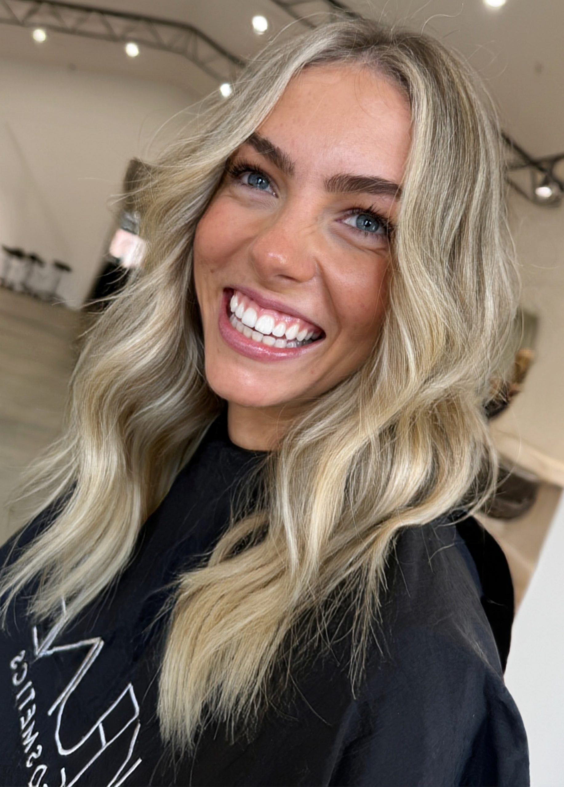 Lived-in blonde with warm tones and soft waves by Hairko Studio